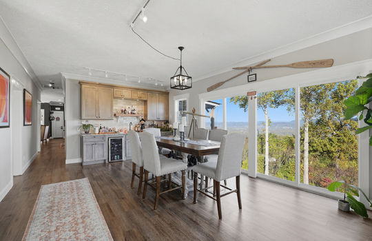 family room, wet bar, sink, tile backsplash, wine cooler, mini fridge, large windows, mountain views, luxury vinyl flooring, hallway