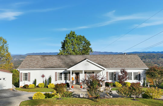 mountain views, modular home, vinyl siding, driveway, landscaping, covered front porch, front door, detached garage