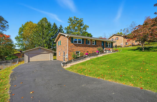 driveway view, brick ranch, brick exterior, driveway, detached garage, sidewalk, landscaping, front yard, trees, front steps, front door