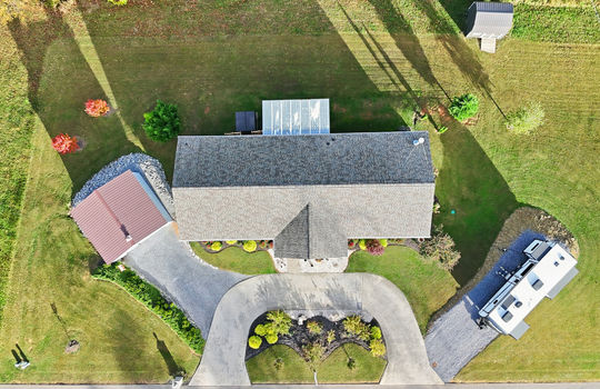 overhead aerial view of home, roof, RV parking area, detached garage, shed, driveway, front yard, back yard, landscaping