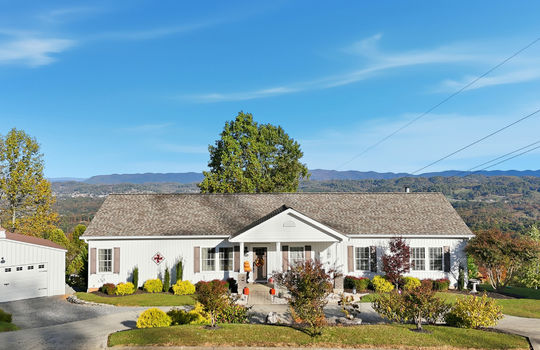 modular home, detached garage, driveway, covered front porch, mountain views