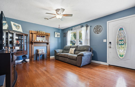 living room, front door, hardwood flooring, window, ceiling fan