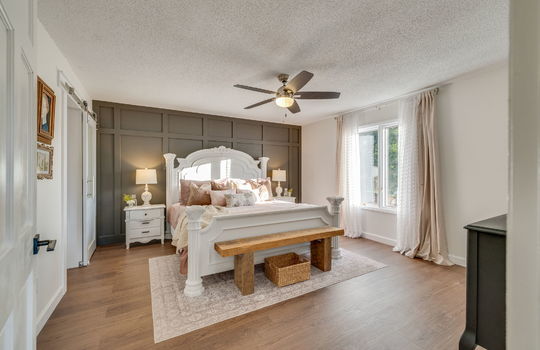 primary bedroom, board and batten feature wall, luxury vinyl flooring, ceiling fan, window