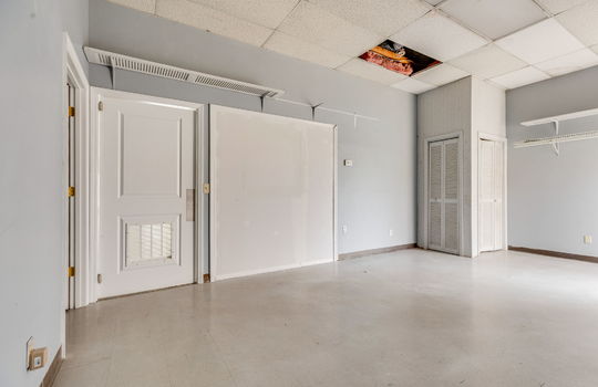 Private office space or employee break room, tile flooring, Ceiling tiles, fluorescent lighting, storage shelves