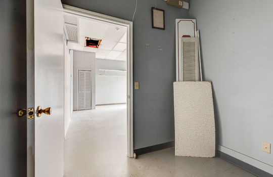 private office space, tile flooring, door to employee breakroom/storage space