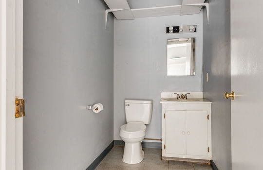 employee bathroom, tile flooring, shelving, toilet, sink
