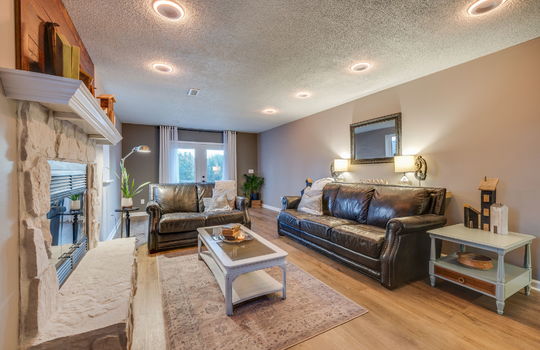 den area, luxury vinyl flooring, painted stone fireplace, furnished mockup