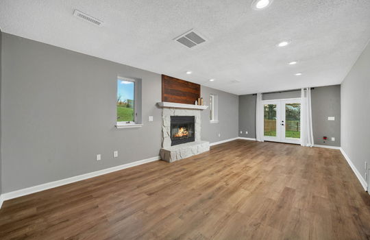 den, fireplace, door to backyard, luxury vinyl flooring, windows