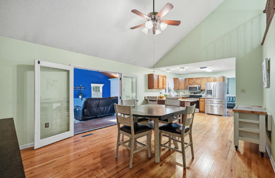 dining area, hardwood flooring, ceiling fan, vaulted ceilings, double doors to sunroom, view toward kitchen