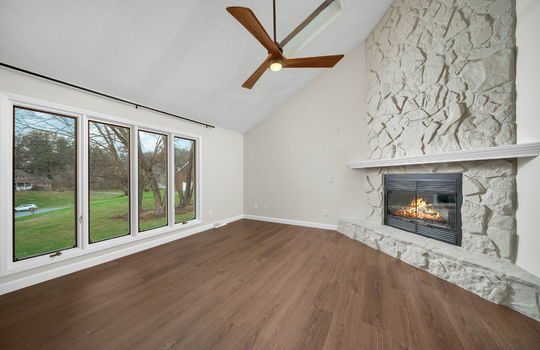 living room, windows, ceiling fan, skylights, painted stone fireplace, luxury vinyl flooring