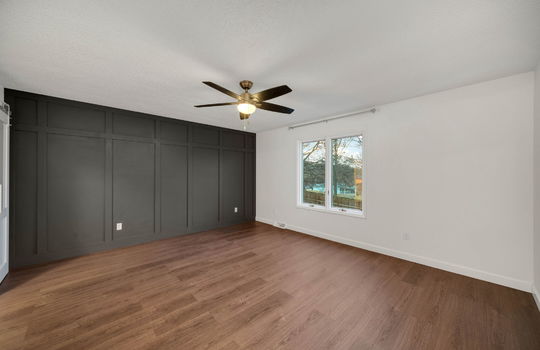 primary bedroom, ceiling fan, luxury vinyl flooring, window, board and batten feature wall