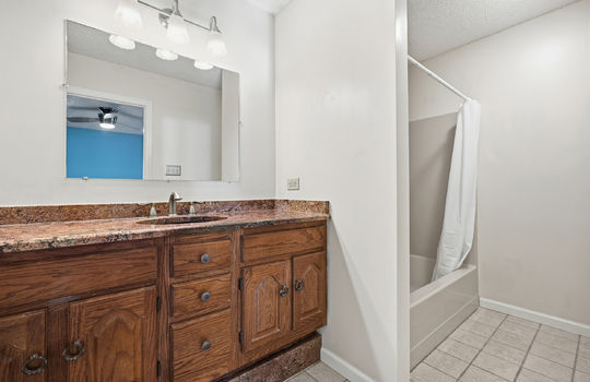 second ensuite bathroom, granite countertops, sink, shower/tub, tile flooring
