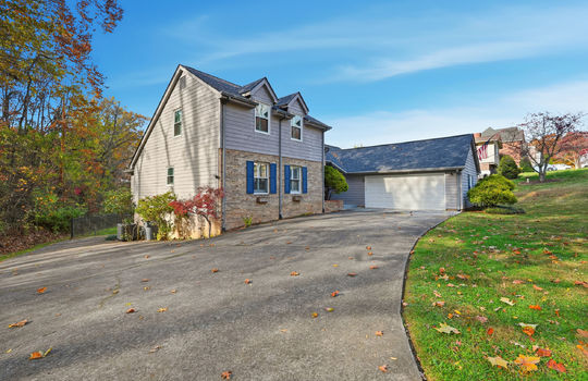 driveway, traditional style home, brick, wood siding, garage, two car garage, landscaping, front yard