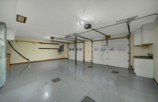 garage, two car garage, garage doors, concrete flooring, cabinets