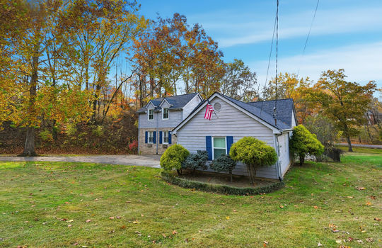 traditional style home, landscaping, front yard, wood siding, brick, driveway, trees