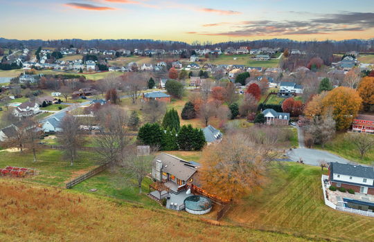 aerial view of back of home, neighboring homes, fencing, back yard, back deck, trees, landscaping