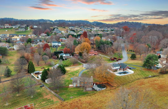 aerial view of back of home, neighboring homes, fencing, back yard, back deck, trees, landscaping, mountains