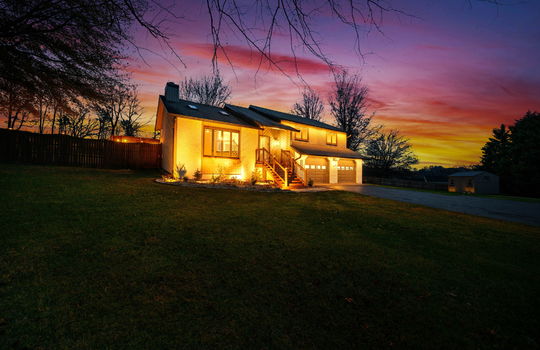 twilight photo, contemporary home, garage doors, wood siding, driveway, fencing, stairs to front door