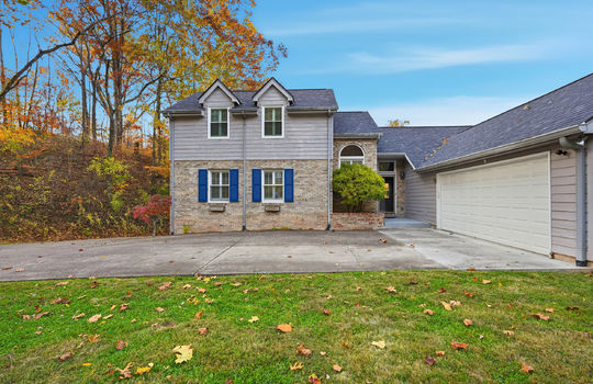 traditional style home, garage, two car garage, driveway, wood siding, brick, front door, trees