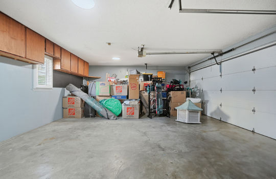 garage, garage door, concrete flooring, cabinets, window