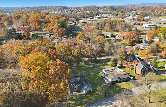 aerial photo of home, road, driveway, trees, back yard, neighboring homes, mountains