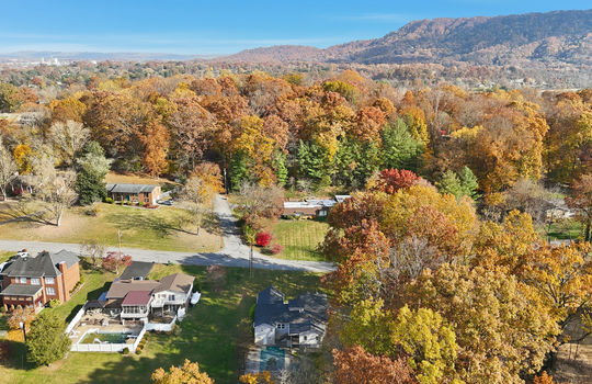 aerial photo of home, road, driveway, trees, back yard, neighboring homes, mountains