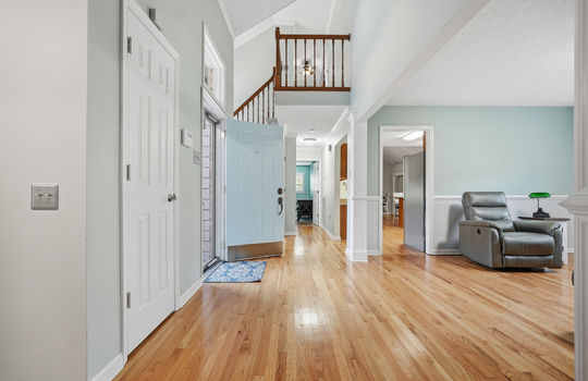 view toward front door, hardwood flooring, living room, kitchen