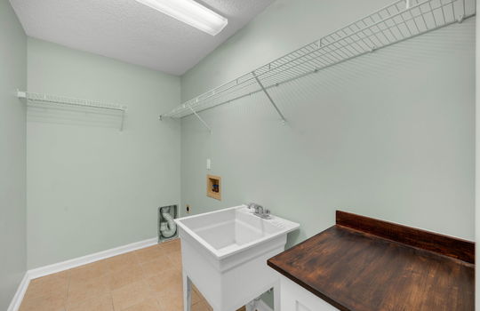 laundry room, wire shelving, utility sink, washer/dryer hookups, tile flooring