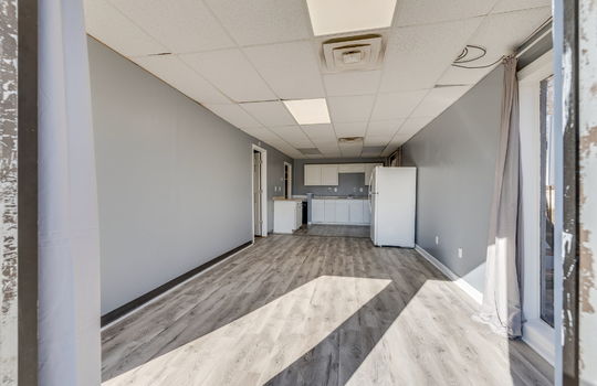 open floor plan, living room, kitchen, luxury vinyl flooring, kitchen cabinets, refrigerator, electric range, sink, ceiling tiles