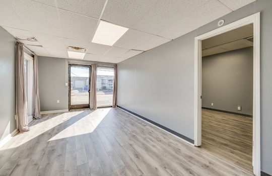 living room, space, doorway to bedroom, windows, luxury vinyl flooring
