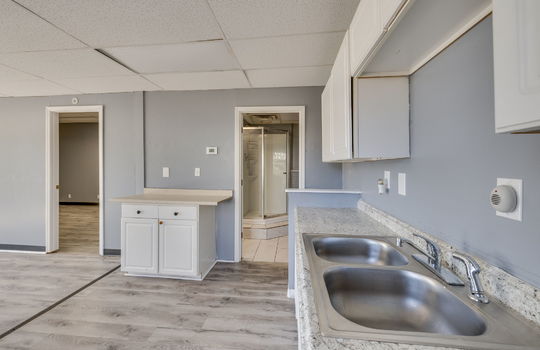 kitchen, sink, cabinets, countertops, doorway to bedroom, doorway to bathroom