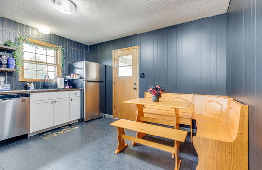 kitchen, paneling walls, tile backsplash, stainless refrigerator and dishwasher, sink