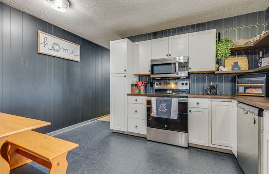 kitchen, tile backsplash, cabinets, butcher block countertops, stainless appliances, microwave, oven, dishwasher, open shelving