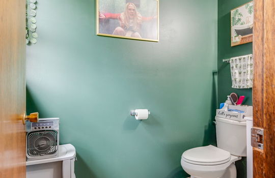 attached half bath, luxury vinyl flooring, toilet, sink