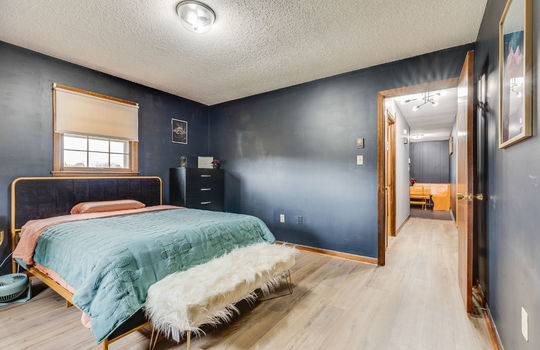 bedroom, luxury vinyl flooring, window, door to hallway
