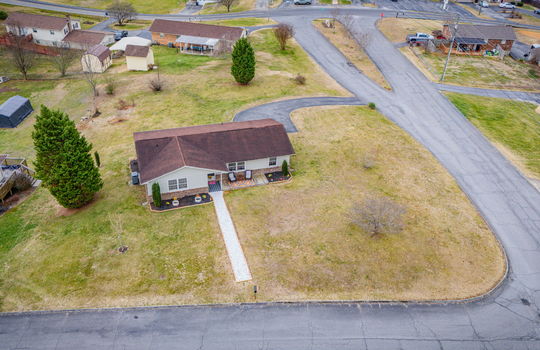 aerial view of home, front yard, gravel sidewalk, ranch style home, back yard, driveway, road, neighboring homes