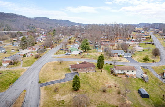 aerial view of home, back yard view, neighboring homes, mountain views, back yard, driveway, carport, brick exterior, front yard, roads, neighboring homes