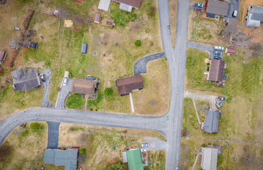 overhead aerial view of home, road, front yard, roof, driveway, back yard, neighboring homes