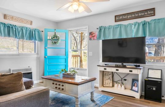 living room, window, front door, ceiling fan, luxury vinyl flooring, storm door
