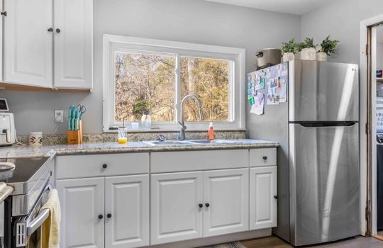 kitchen, laminate countertops, cabinets, stainless appliances, stove, refrigerator, sink, window above sink, door to laundry space