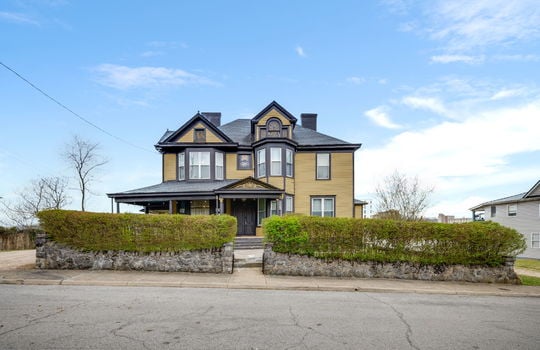 Victorian home, sidewalk, hedge, front door, covered porch, wood siding