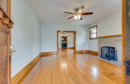 living room, fireplace, hardwood flooring, windows, ceiling fan