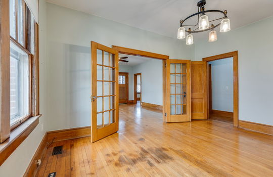 dining area, french doors, hardwood flooring, chandelier, door way to hallway