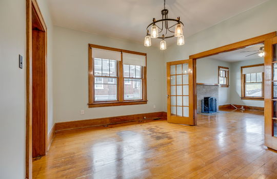 dining room, french doors to living room, window, chandelier, hardwood flooring
