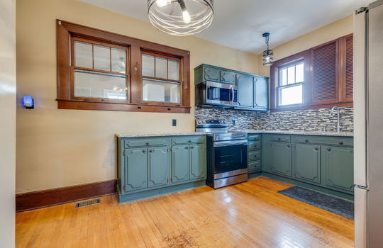 kitchen, cabinets, granite countertops, tile backsplash, range, built-in microwave, sink, window