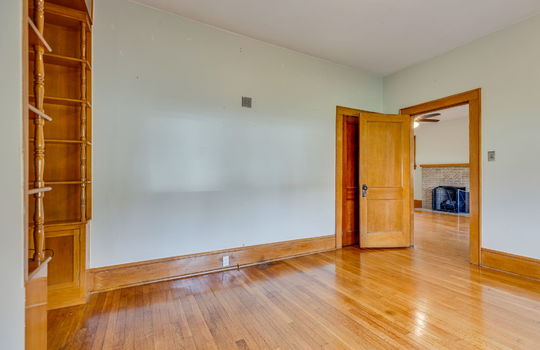 bonus room/home office , wood built-in shelving nook, closet, hardwood flooring, wood trim, door