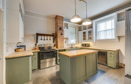 kitchen, tile flooring, butcher block countertops, kitchen island, cabinets, countertops, windows, sink, refrigerator, range