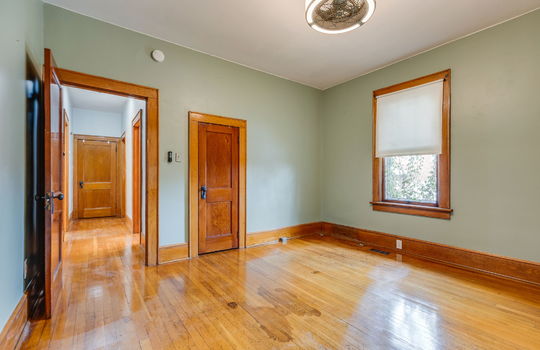 bedroom, closet, window, wood trim, hardwood flooring, ceiling fan, wood doors