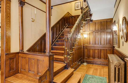 stairwell, wood stairs, radiator, wood wall feature, wood wainscoting, wood trim, Victorian wood trim, hardwood flooring, built-in wood bench