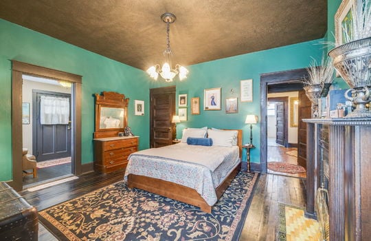 bedroom, hardwood flooring, closet, fireplace, wood mantle, tile, wood trim, chandelier